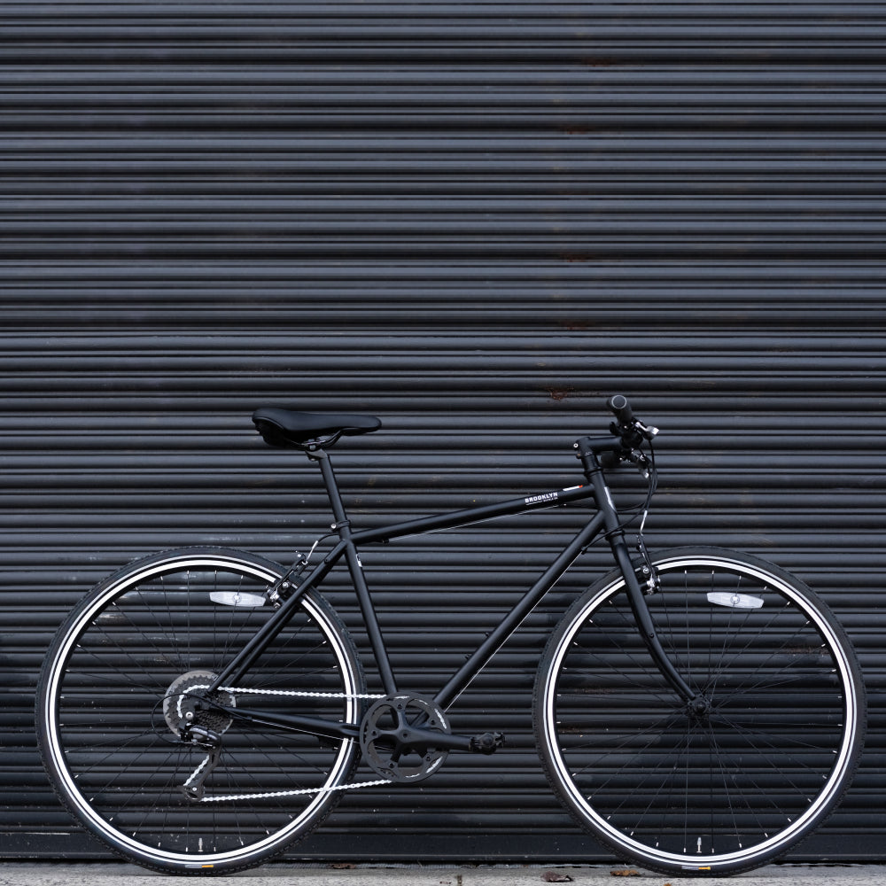 Brooklyn Bicycle Co. Matte Black Roebling against black gate